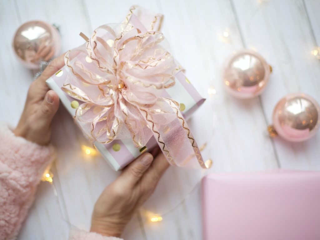a gift packed in pink and white paper and ribbons.