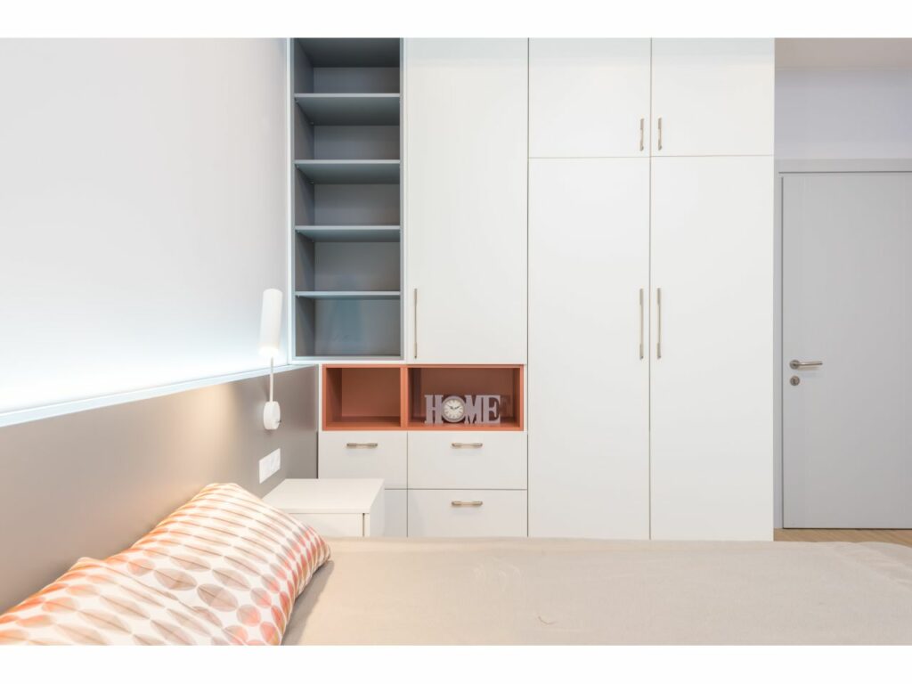 a white themed bedroom with a huge wardrobe and storage space on display.